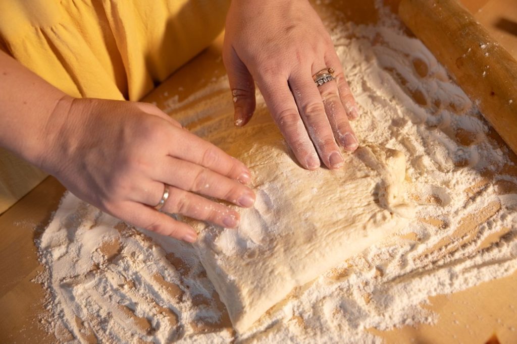 Crafting Captivating Headlines: Your awesome post title goes here Close-up of hands kneading dough on a wooden surface with flour.