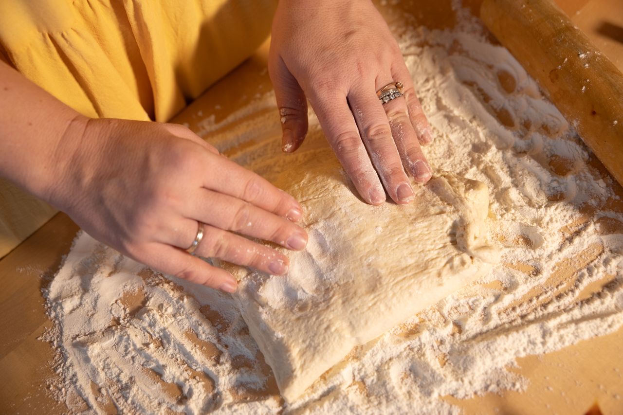 Crafting Captivating Headlines: Your awesome post title goes here Close-up of hands kneading dough on a wooden surface with flour.