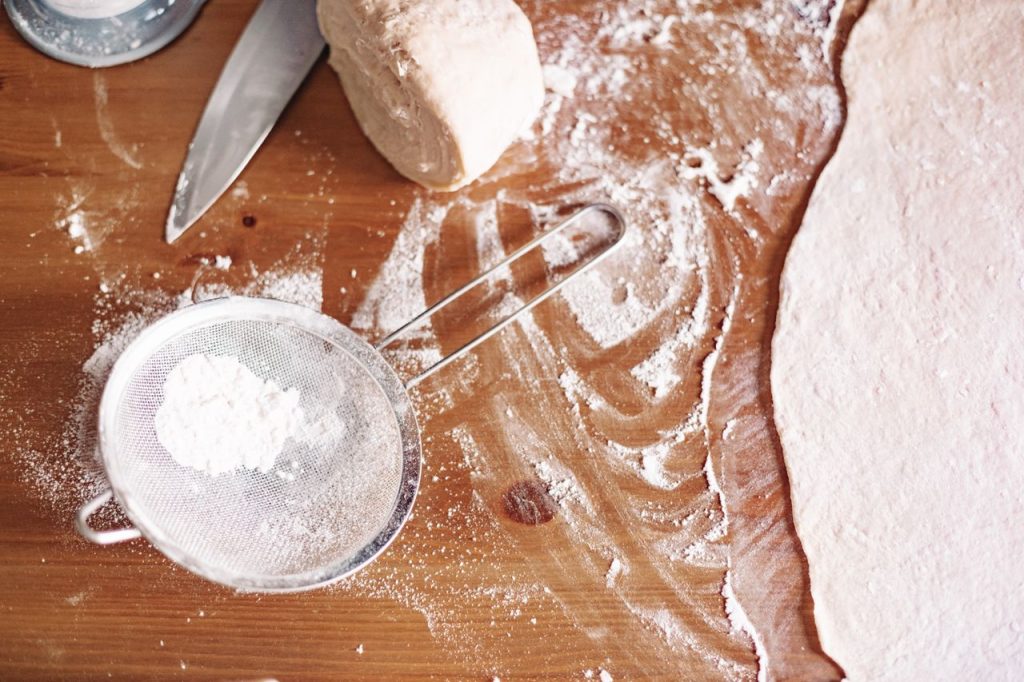 Mastering the First Impression: Your intriguing post title goes here Top view of dough preparation with flour and kitchen tools.